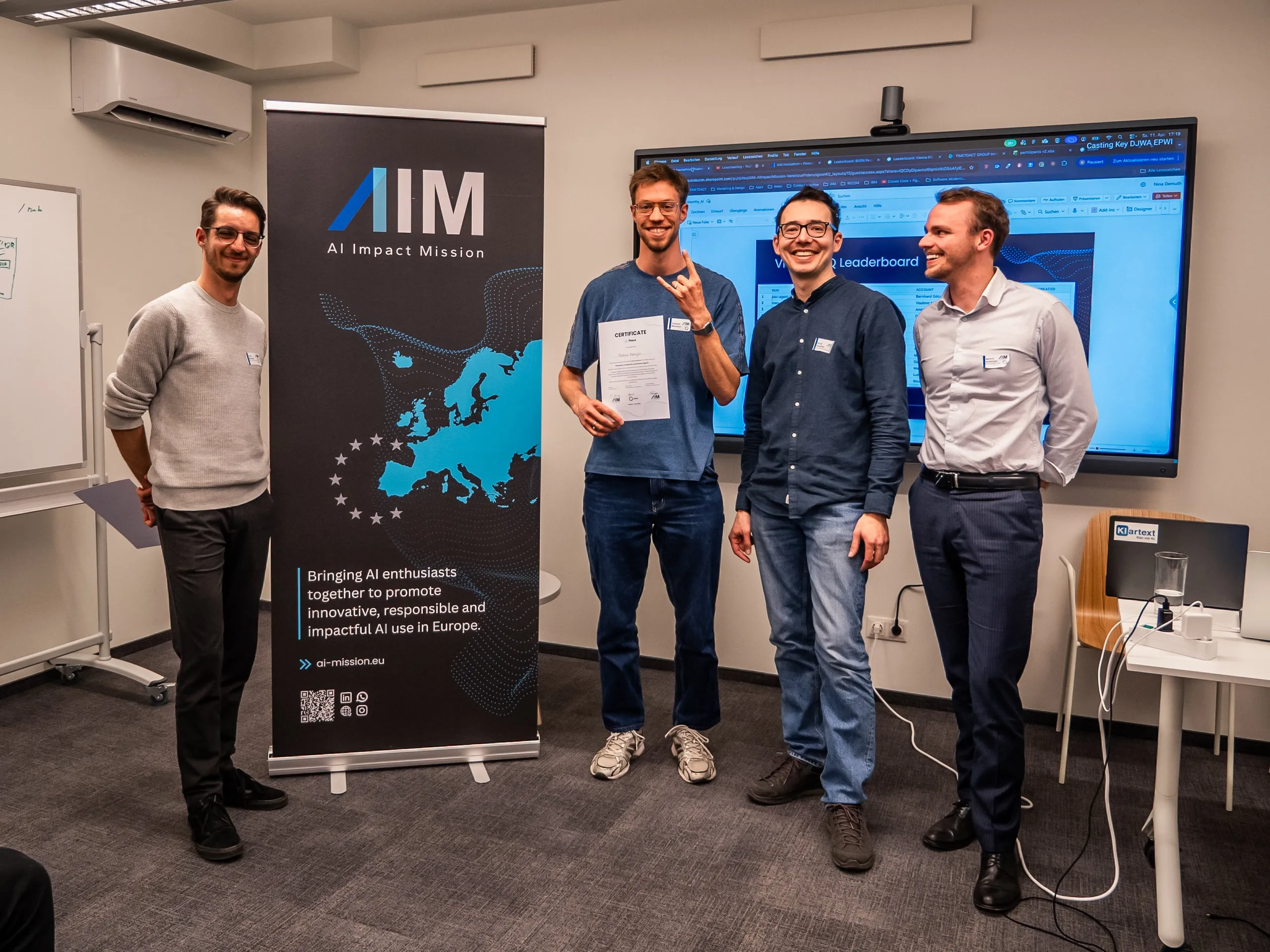 Vladimir Manuilov holding the second-place certificate at AIM Hackathon 4